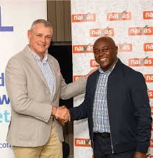 Two men shaking hands at KWETU NEWS event in front of a branded backdrop.