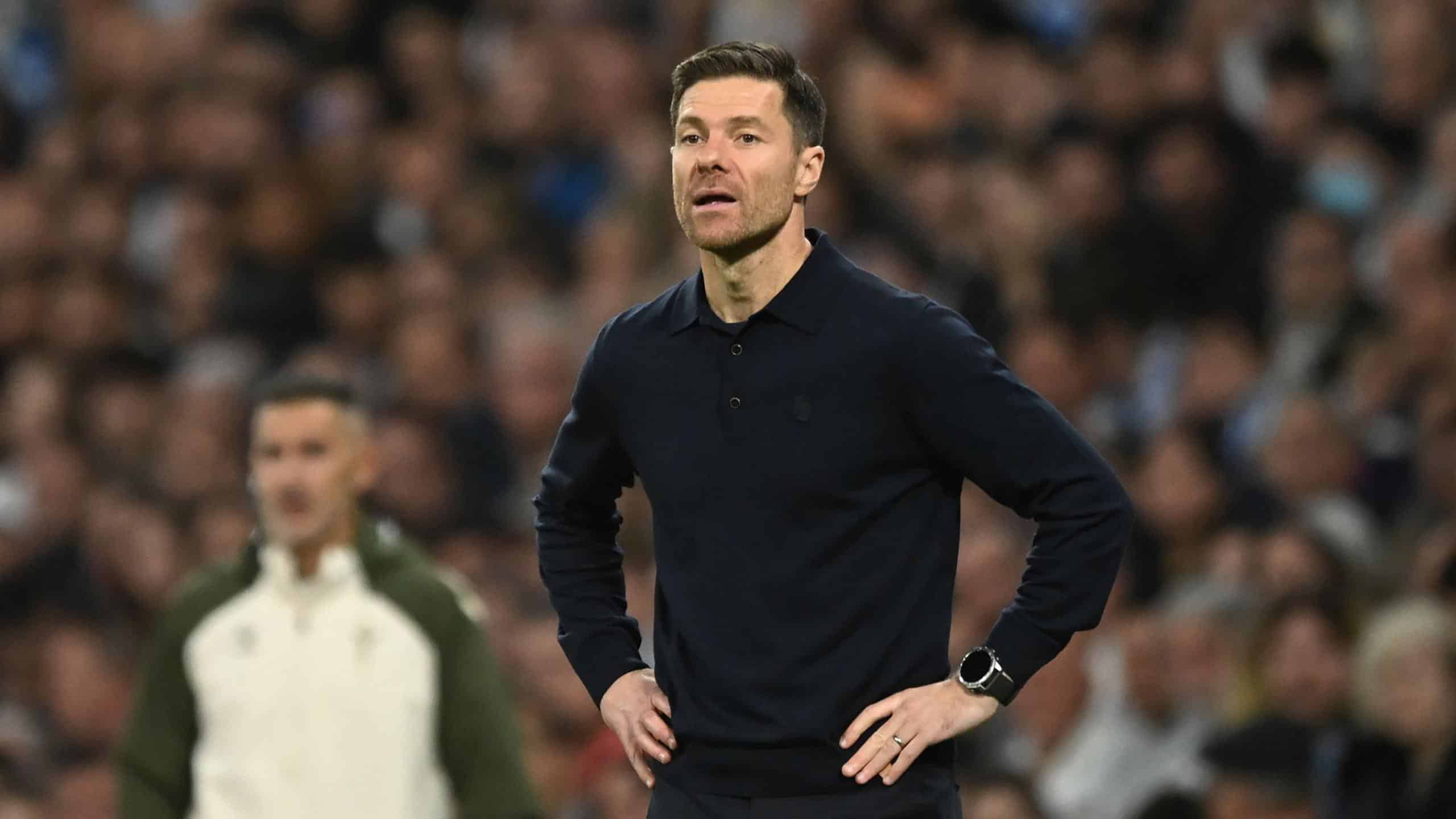 Football coach on the sideline during a match, providing tactical analysis.