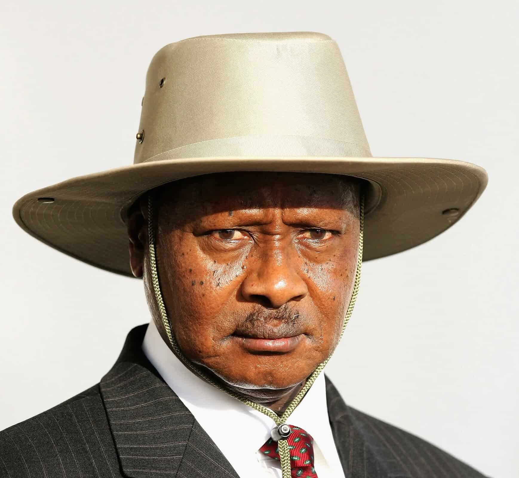 A man wearing a wide-brimmed hat and formal suit, looking serious.