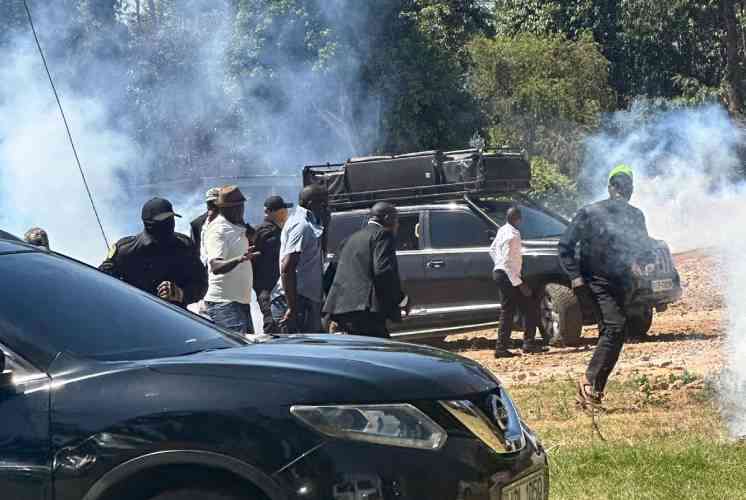 Scene of a vehicle incident with smoke, people gathered around outdoors.