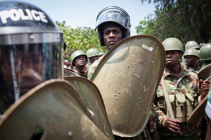 Police officers in riot gear holding shields during a public protest in Kenya.