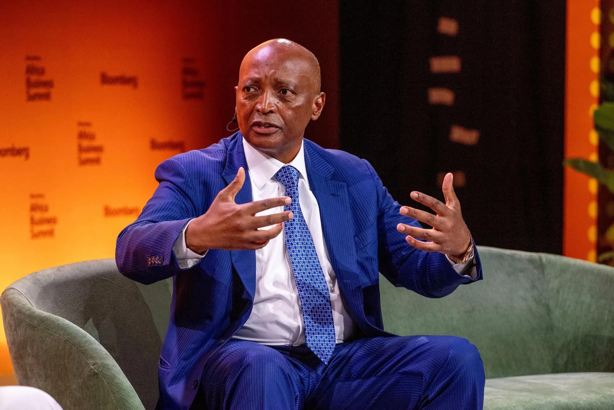 Kenyan man in a blue suit speaking during a TV interview.