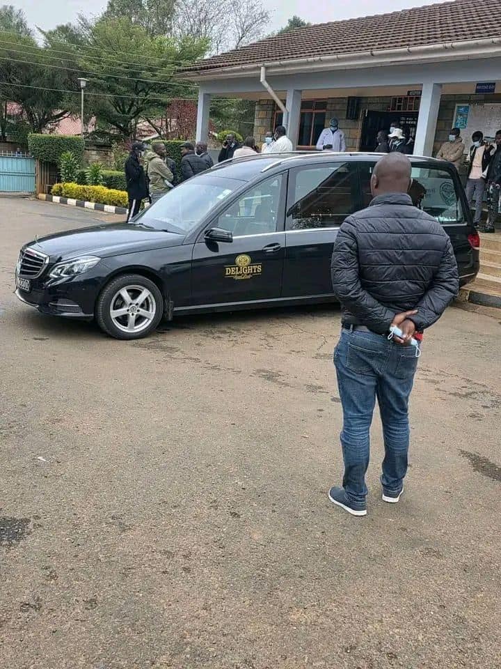 Official vehicle parked outside Kwetuu Collections building in a community setting.
