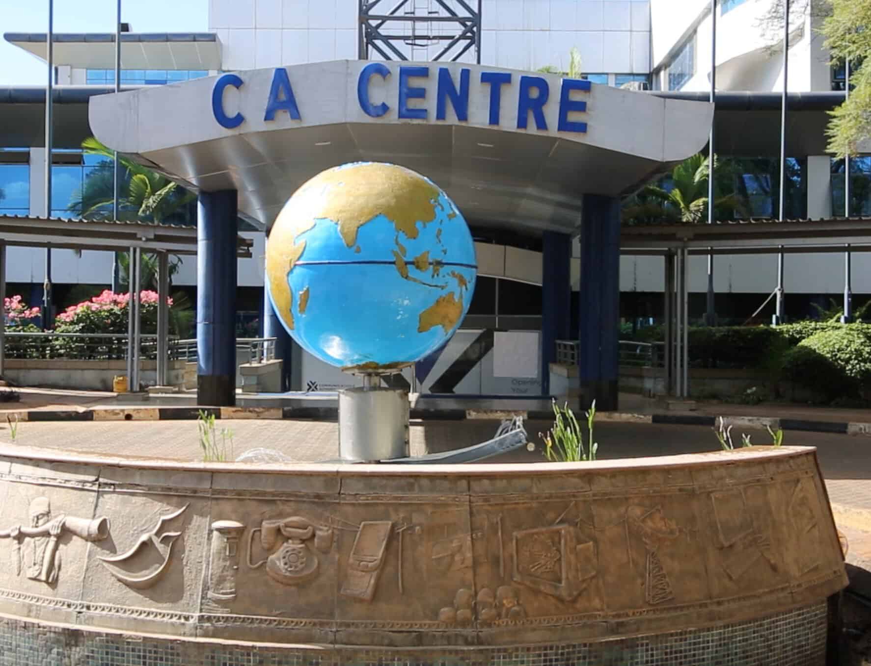Modern office building with a globe sculpture in front.