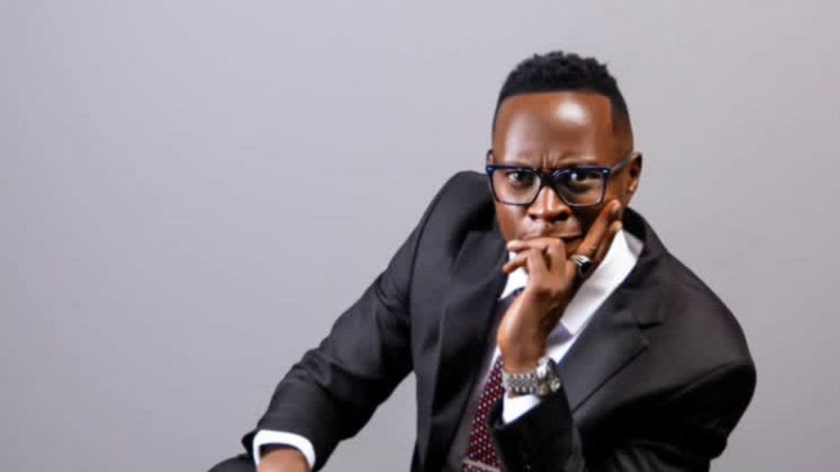 Confident businessman in a suit with glasses, deep in thought, representing KWETU NEWS coverage.