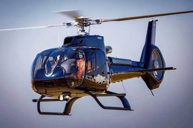 Rescue helicopter flying in the sky with a crew member onboard.
