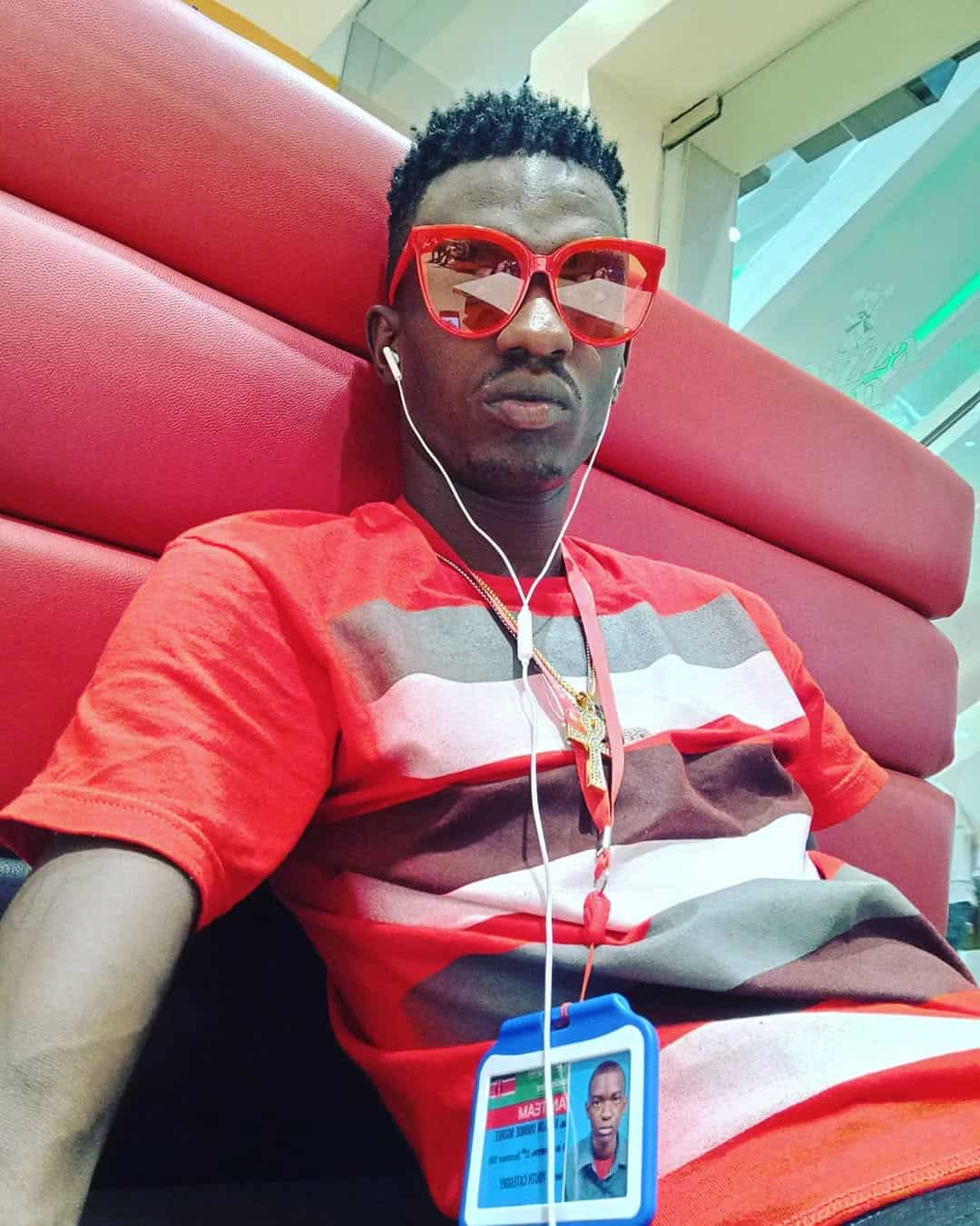 Stylish man wearing red sunglasses and a red, white, and gray striped shirt at Kwetuu Collections.